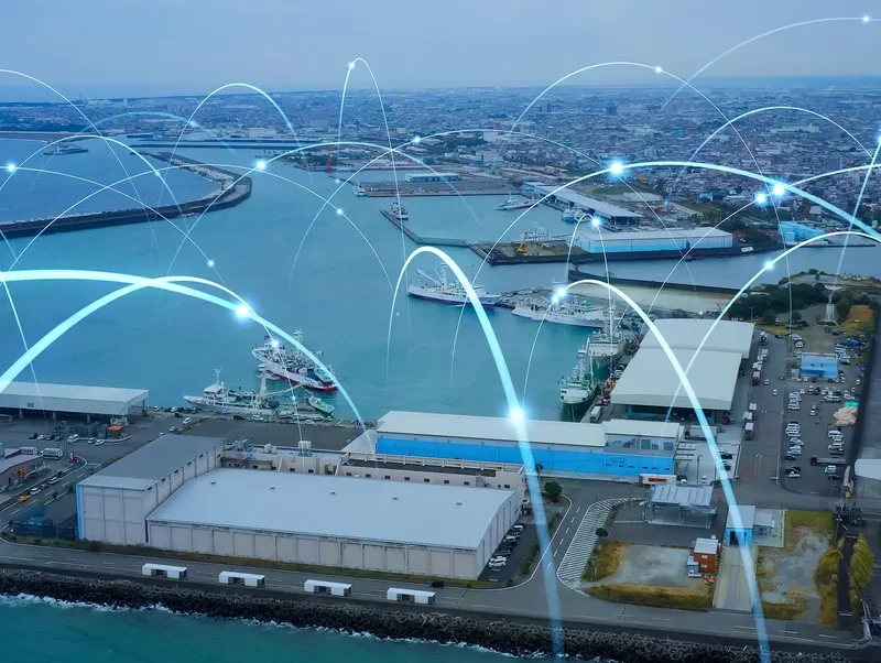 Aerial view of a port with glowing digital network overlay representing connected infrastructure